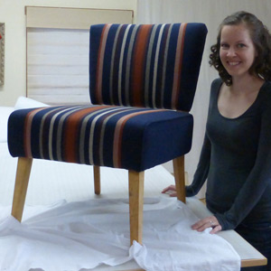 upholstery student with her completed chair